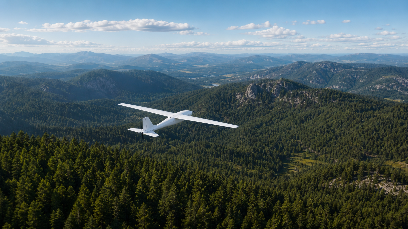 Fixed-wing autonomous aircraft flying above forest ridgelines.