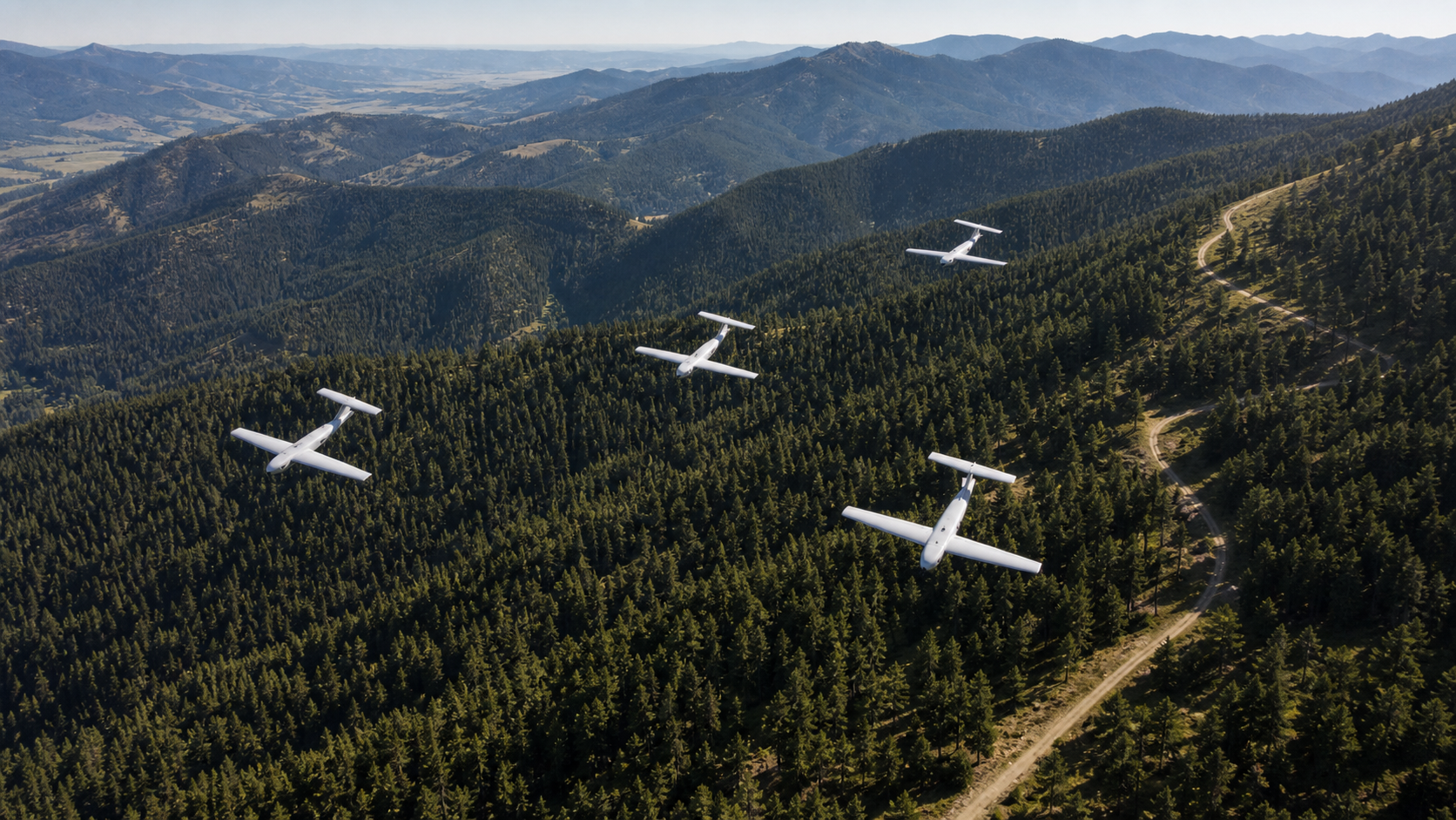 Coordinated autonomous aircraft flying over remote forest terrain.